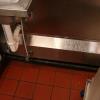 stainless steel chase protects exposed plumbing in a restaurant kitchen